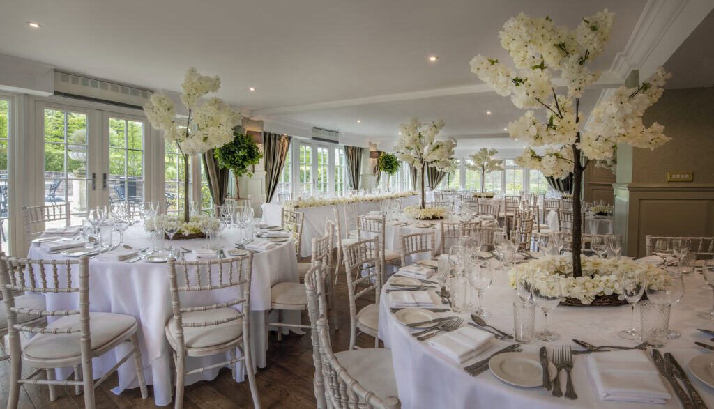 Beautiful banquet hall with floral centrepieces and elegant table settings.
