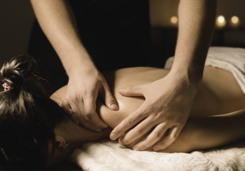 Spa guest receiving a shoulder massage from a therapist